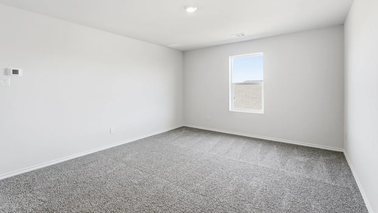 Spacious room featuring neutral paint, gray speckled carpeting, a single window, white trim, and a ceiling light fixture