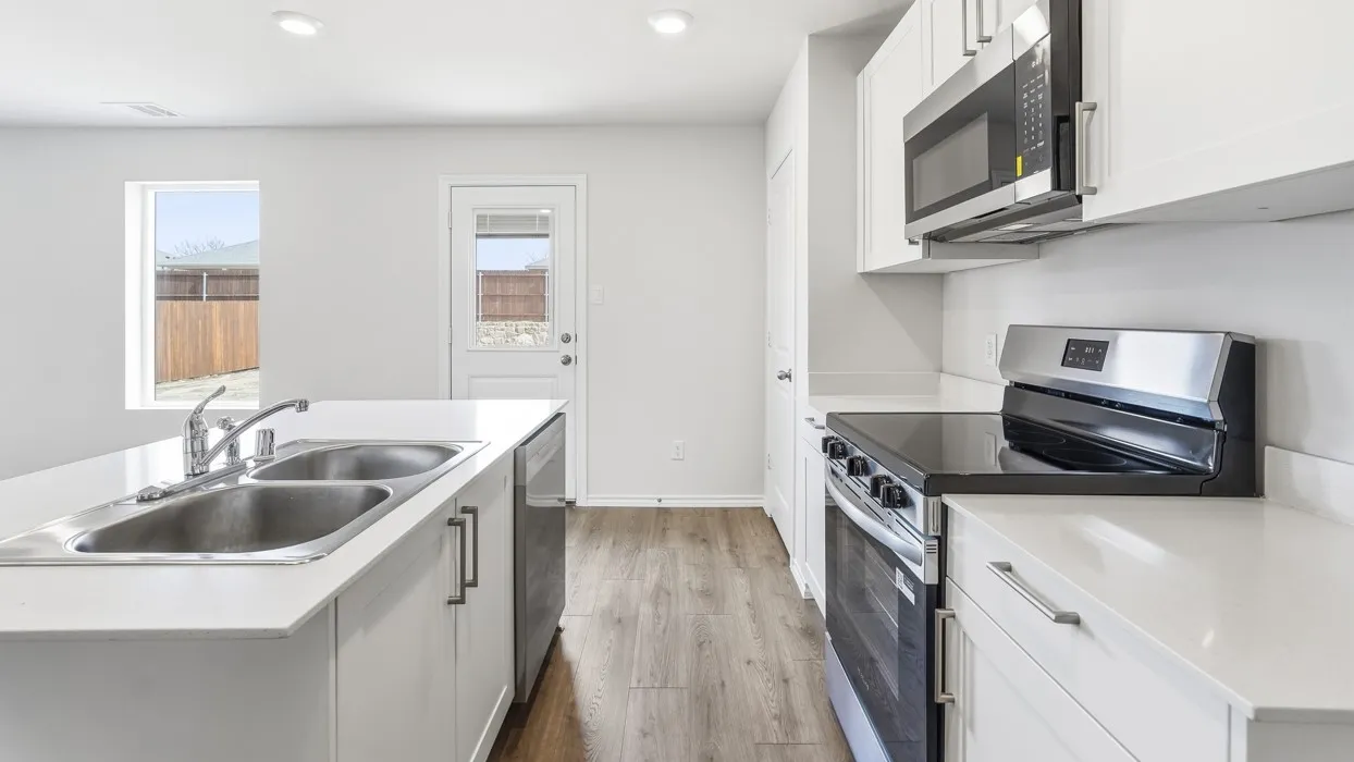 Modern kitchen featuring white cabinetry, light countertops, wood-finish flooring, stainless steel appliances, and recessed lighting