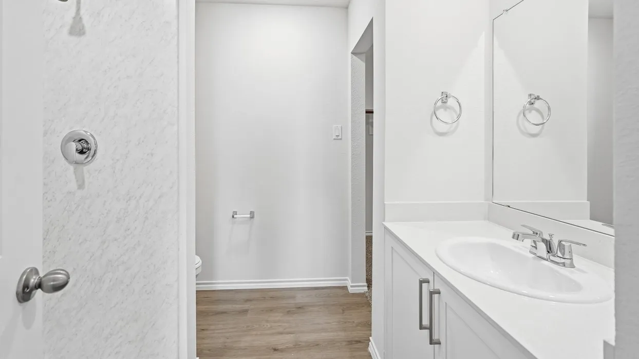 Bathroom vanity featuring an integrated sink, polished chrome faucet, and white countertop