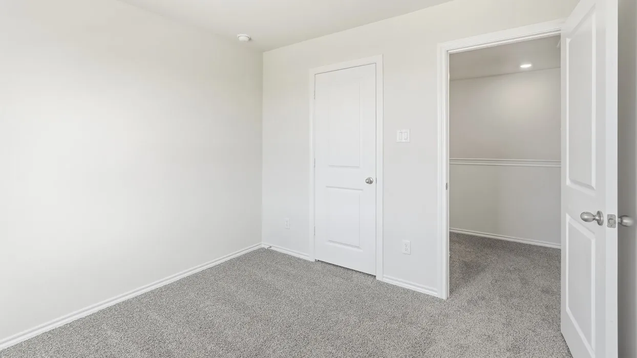 Neutral-toned room featuring light gray carpeting and white baseboards