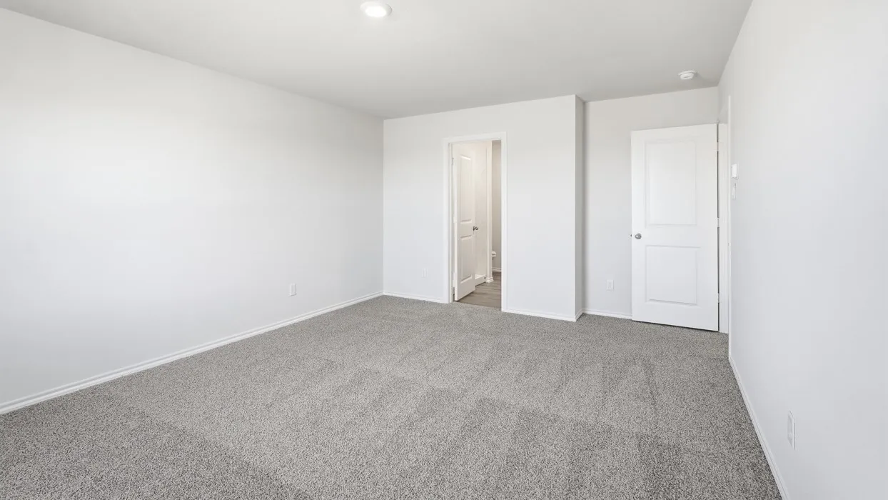 Spacious room featuring light grey carpet flooring, white walls, white baseboards, and a recessed ceiling light
