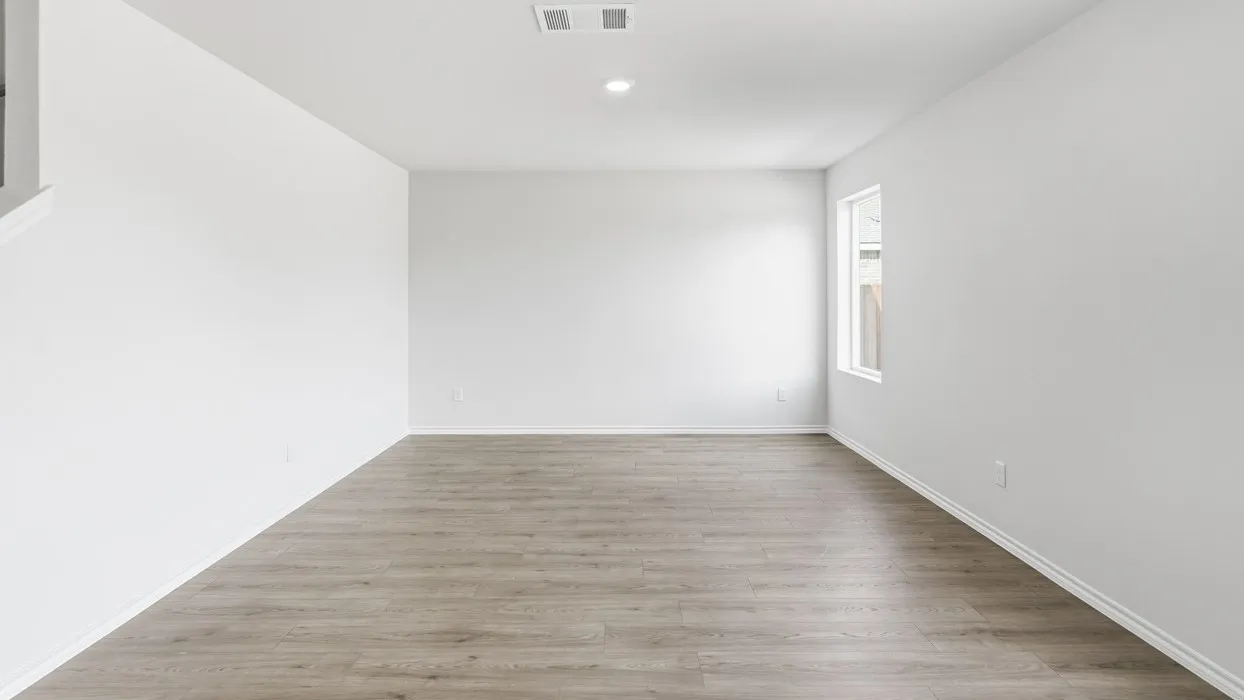 Spacious room featuring light wood-finish flooring, white walls, a single window, and recessed lighting
