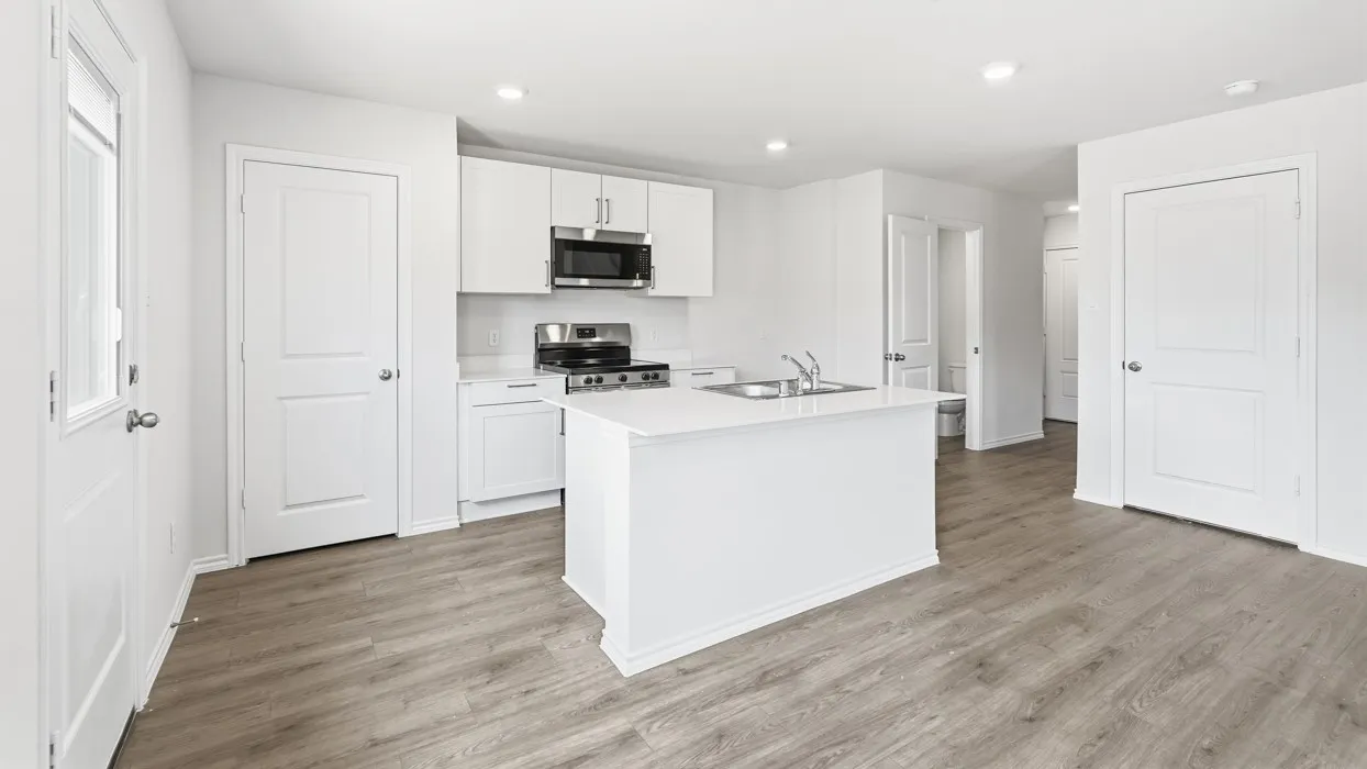 Kitchen featuring white cabinetry, stainless steel appliances, a center island with sink, light-toned wood-finish flooring, and recessed lighting