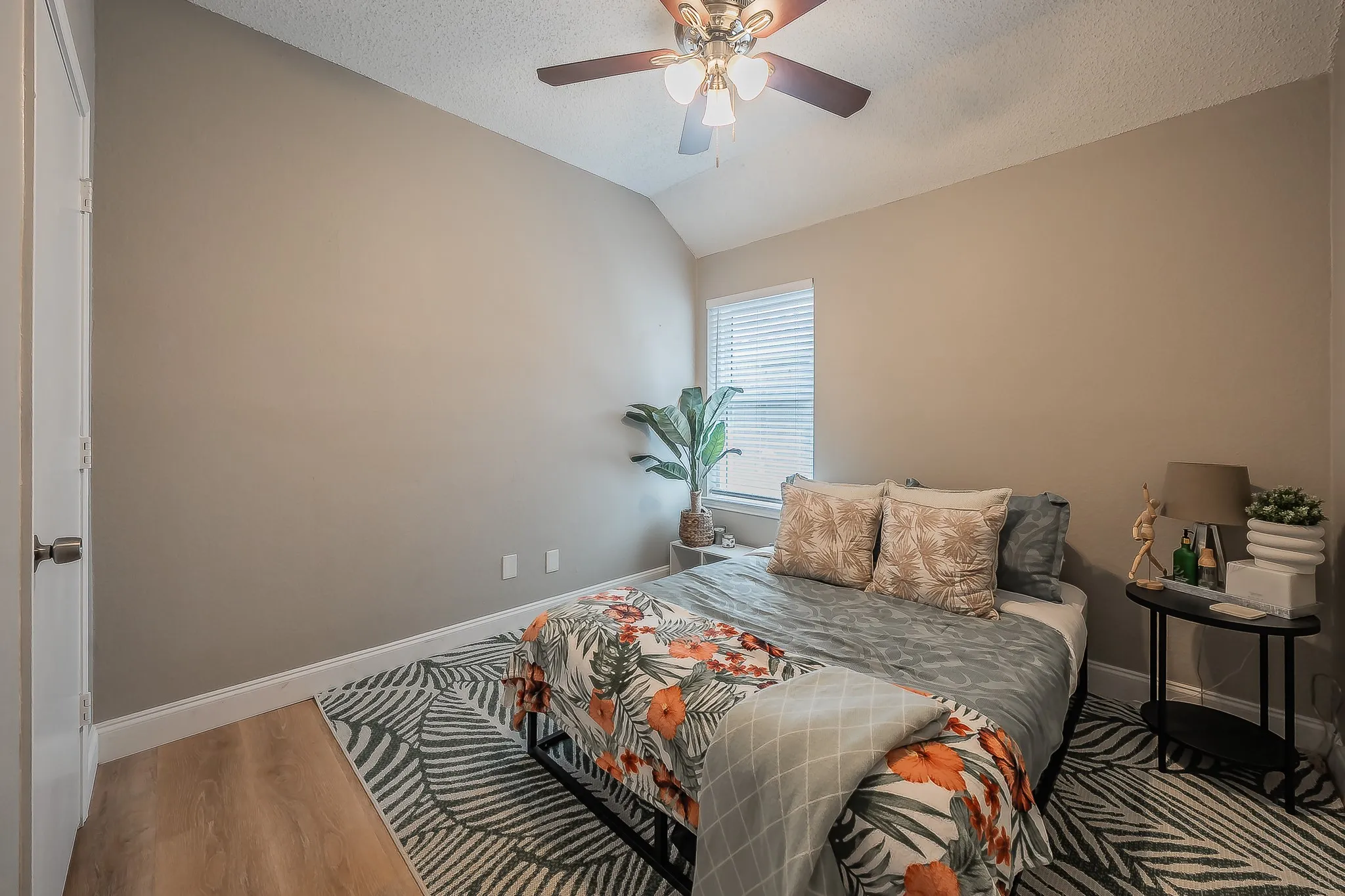 Bedroom featuring wood-finish flooring, a vaulted ceiling, and a ceiling fan with integrated lighting