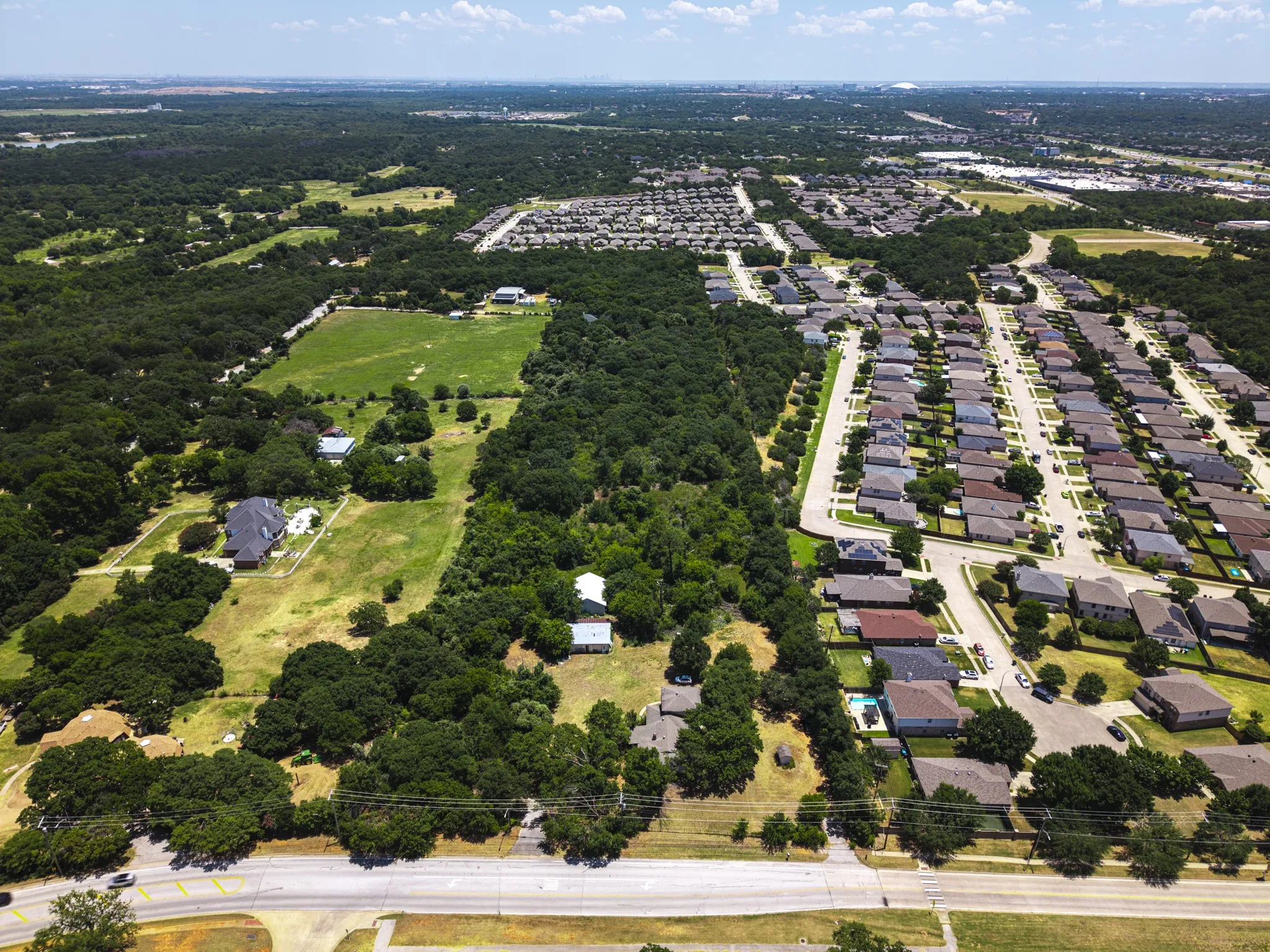 Expansive aerial view of a suburban landscape featuring a mix of residential developments and green spaces