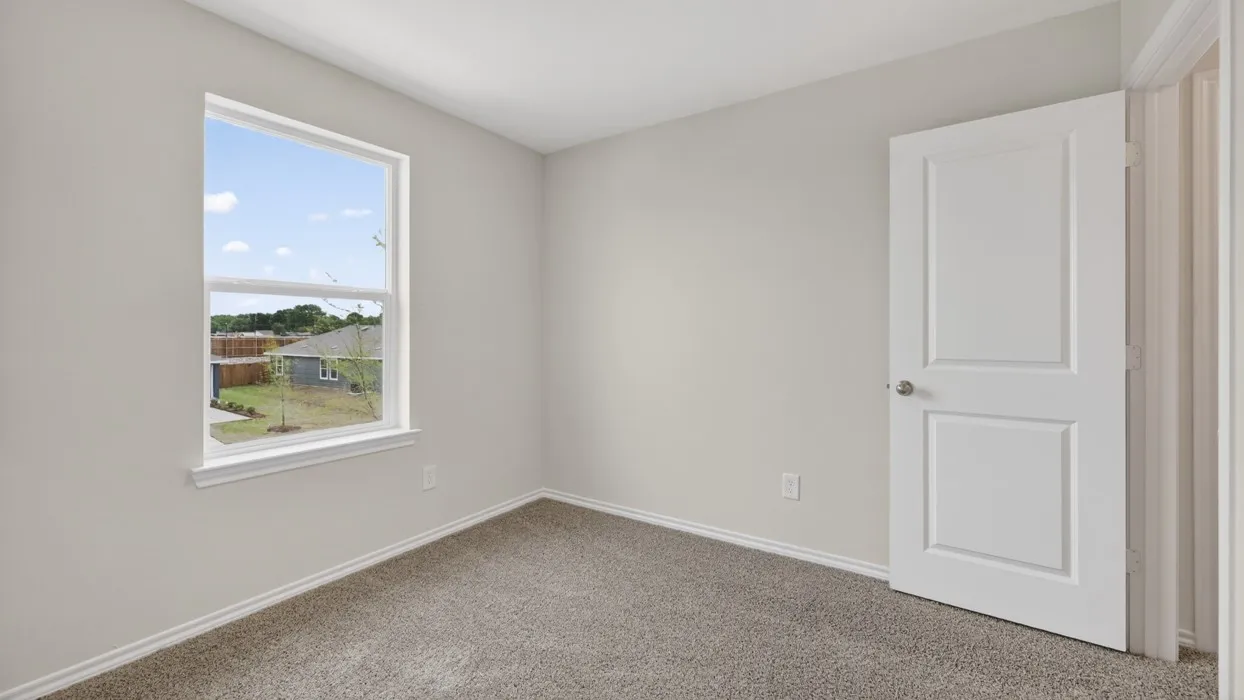 Room featuring a window with white trim, light gray walls, and textured carpet flooring