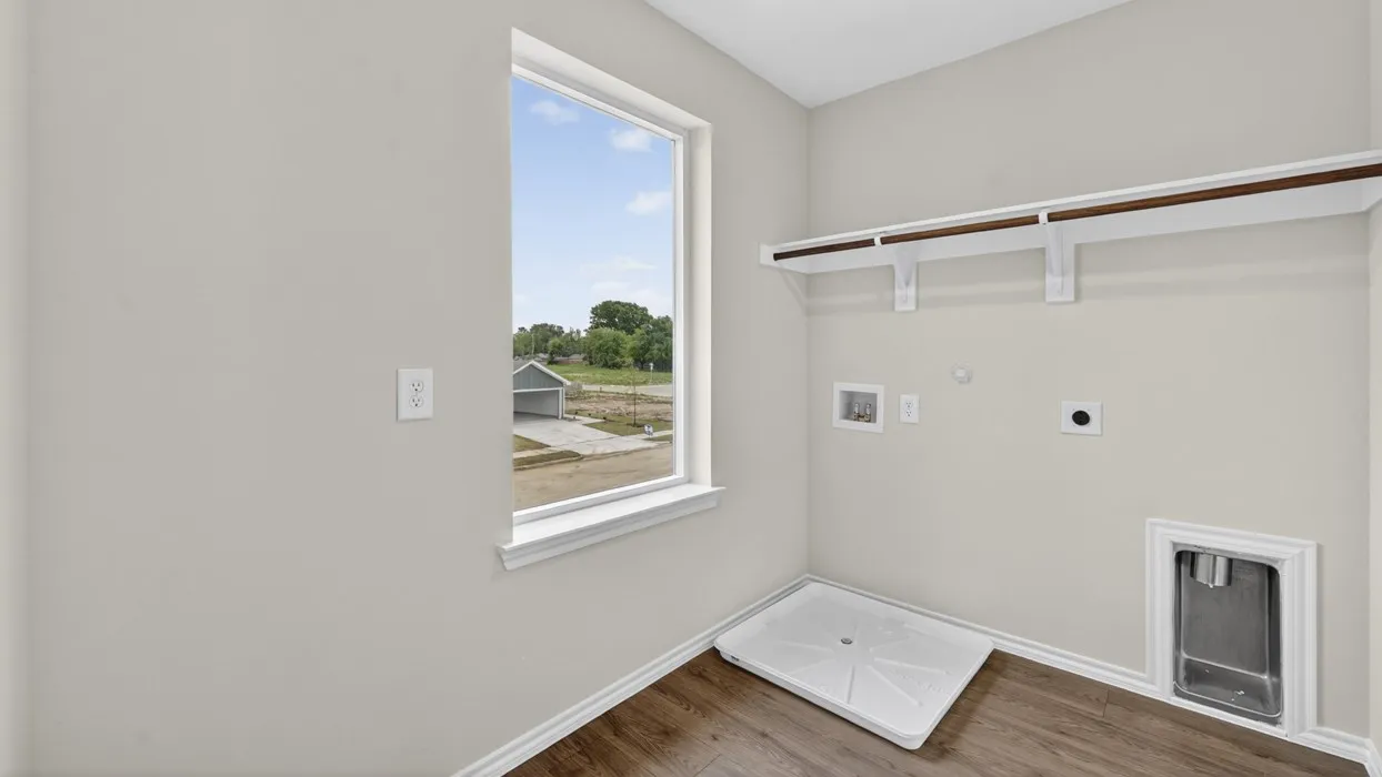 Utility room with wood-finish flooring, light neutral walls, and a large window