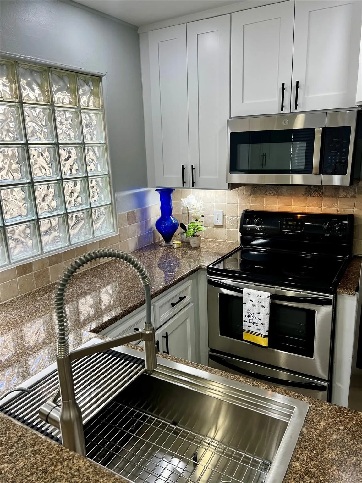 Modern kitchen with white shaker-style cabinetry and black hardware