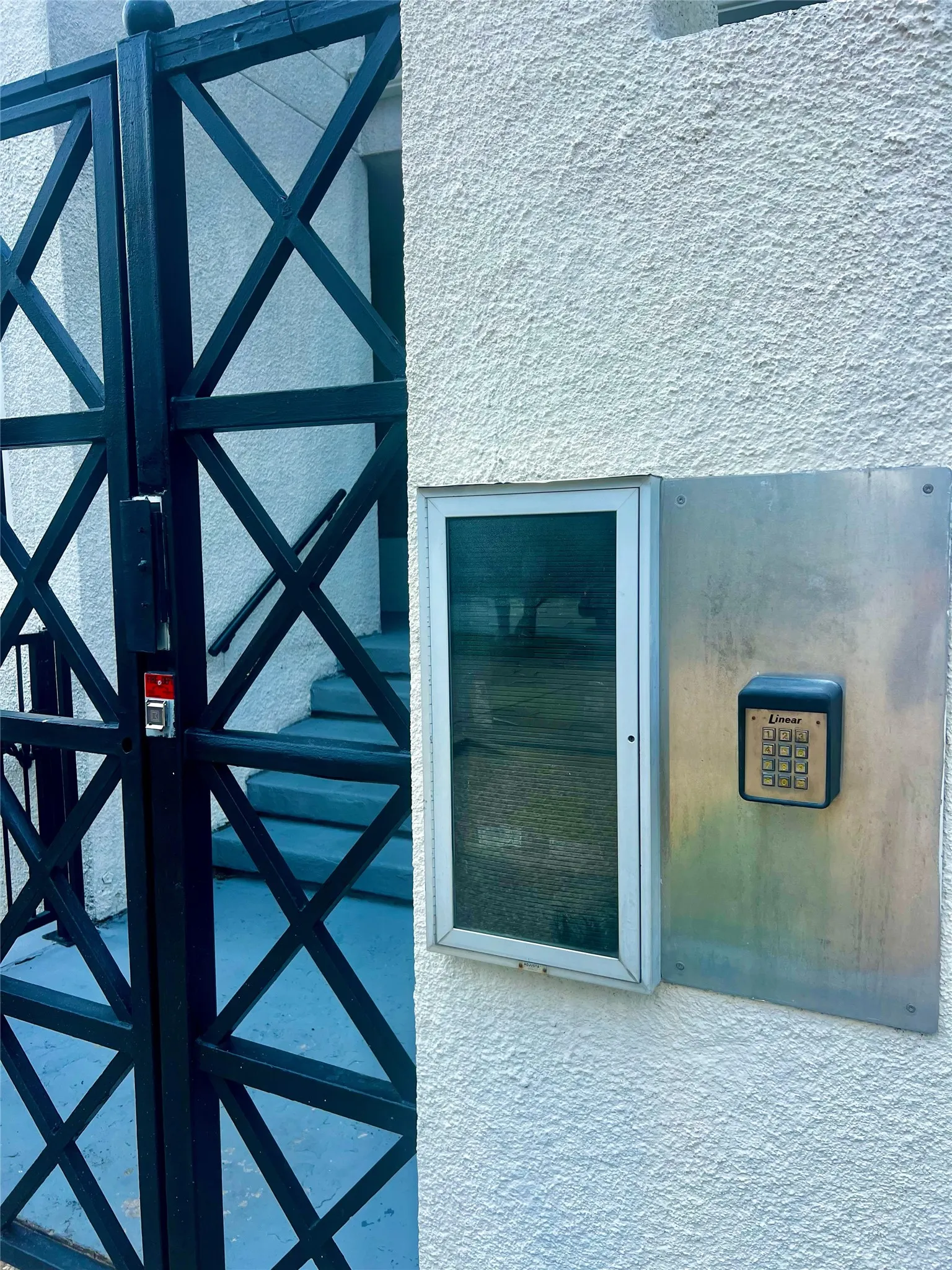 Black metal entry gate with geometric cross detailing