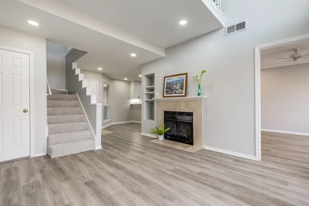 Spacious living area featuring wood-finish flooring, a neutral color palette, and recessed lighting