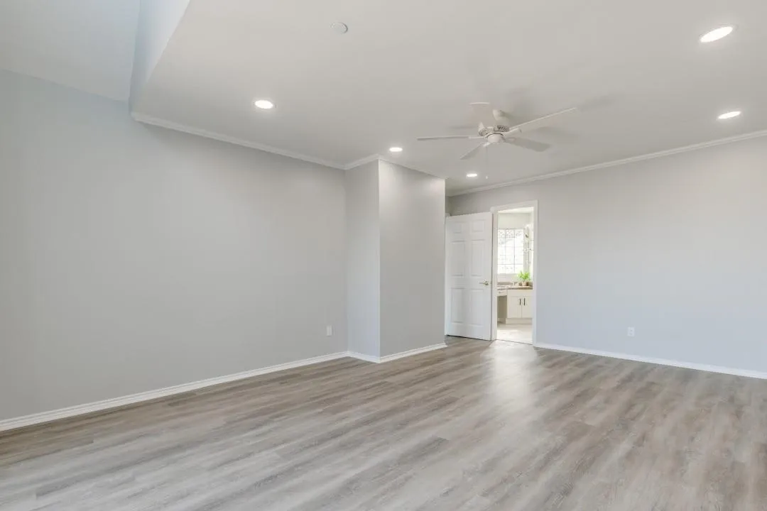 Spacious room featuring wood-finish flooring, recessed lighting, and a ceiling fan