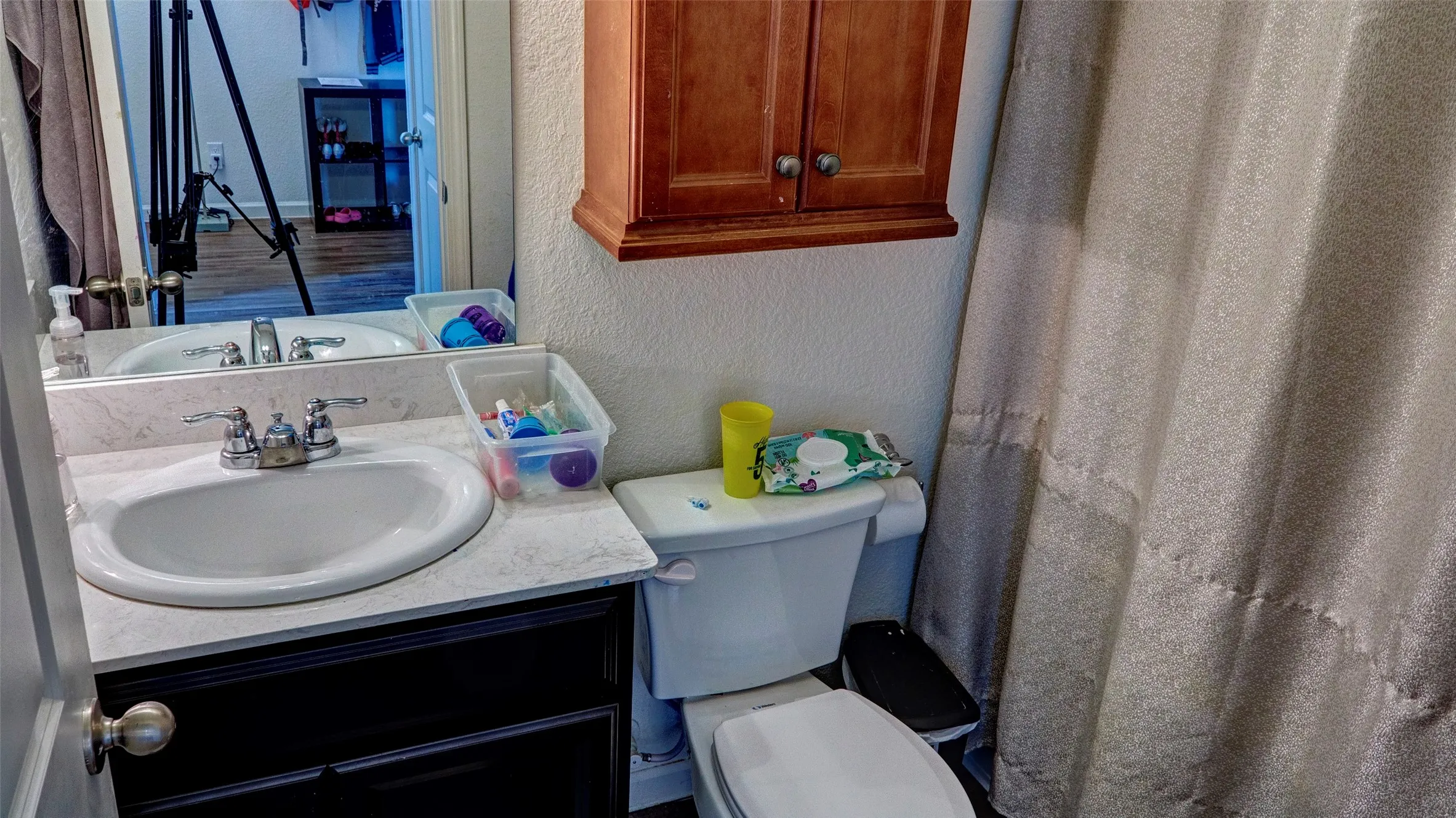 White vanity with a single basin, chrome fixtures, and dark cabinetry