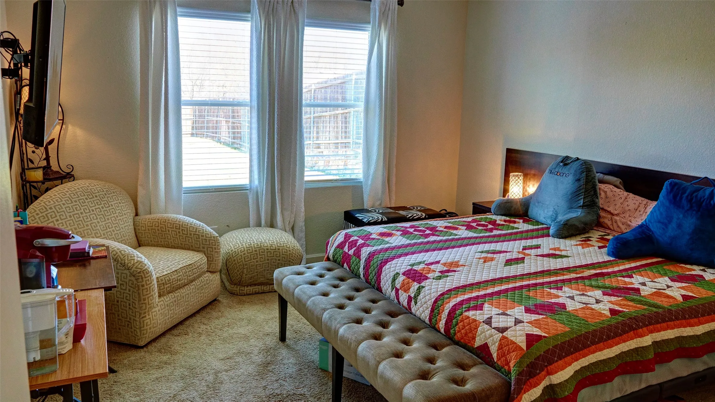 Carpeted bedroom with a built-in headboard and integrated side tables