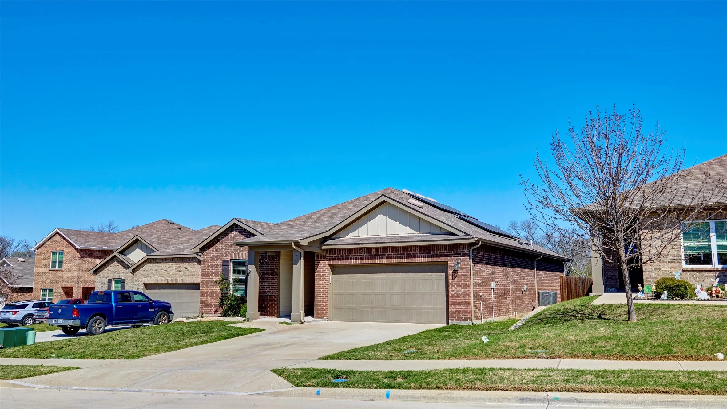 Brick exterior with an attached garage, covered entryway, and asphalt shingle roof