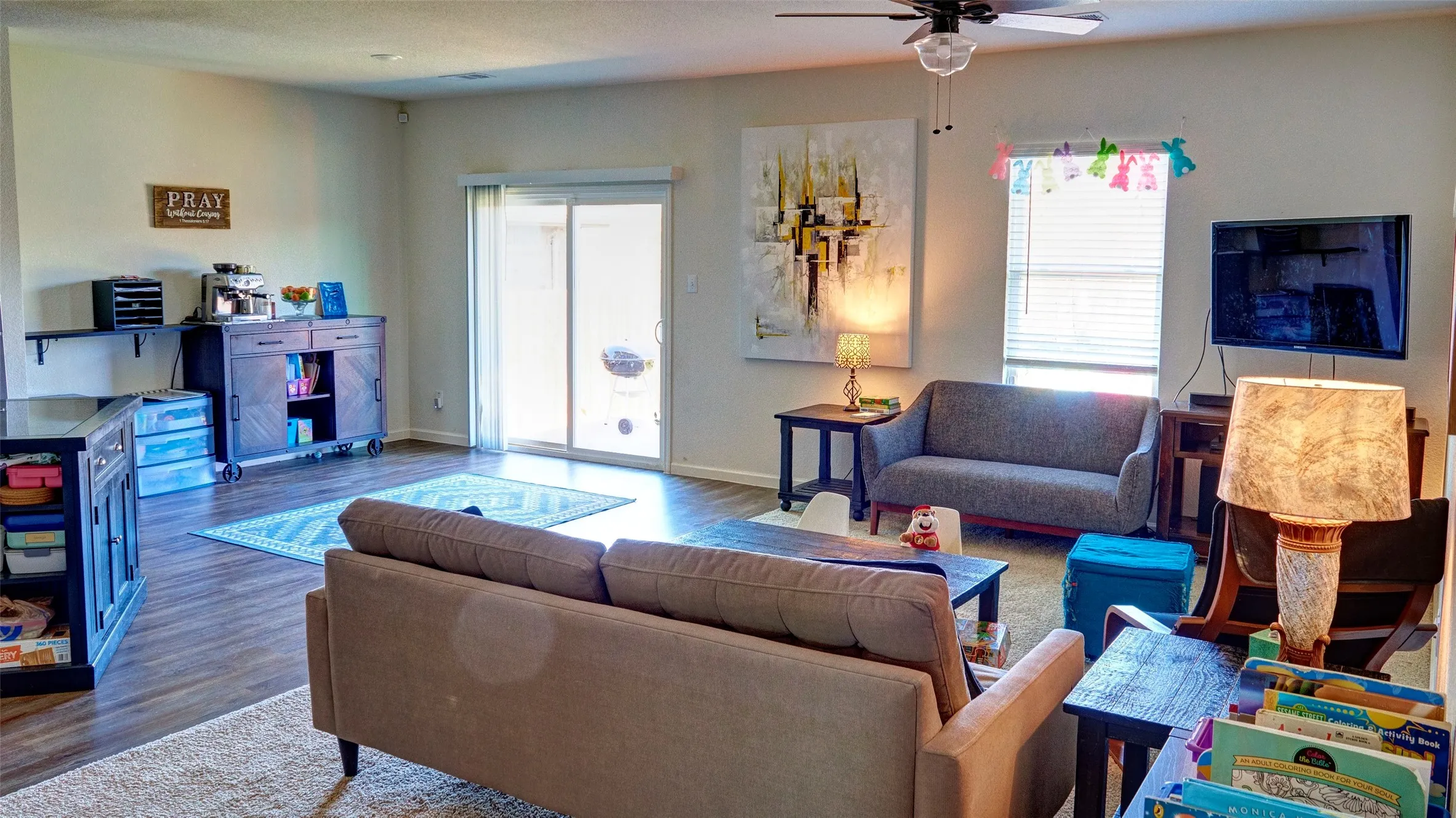 Wood-finish flooring, ceiling fan, white walls, and a sliding glass door to the exterior
