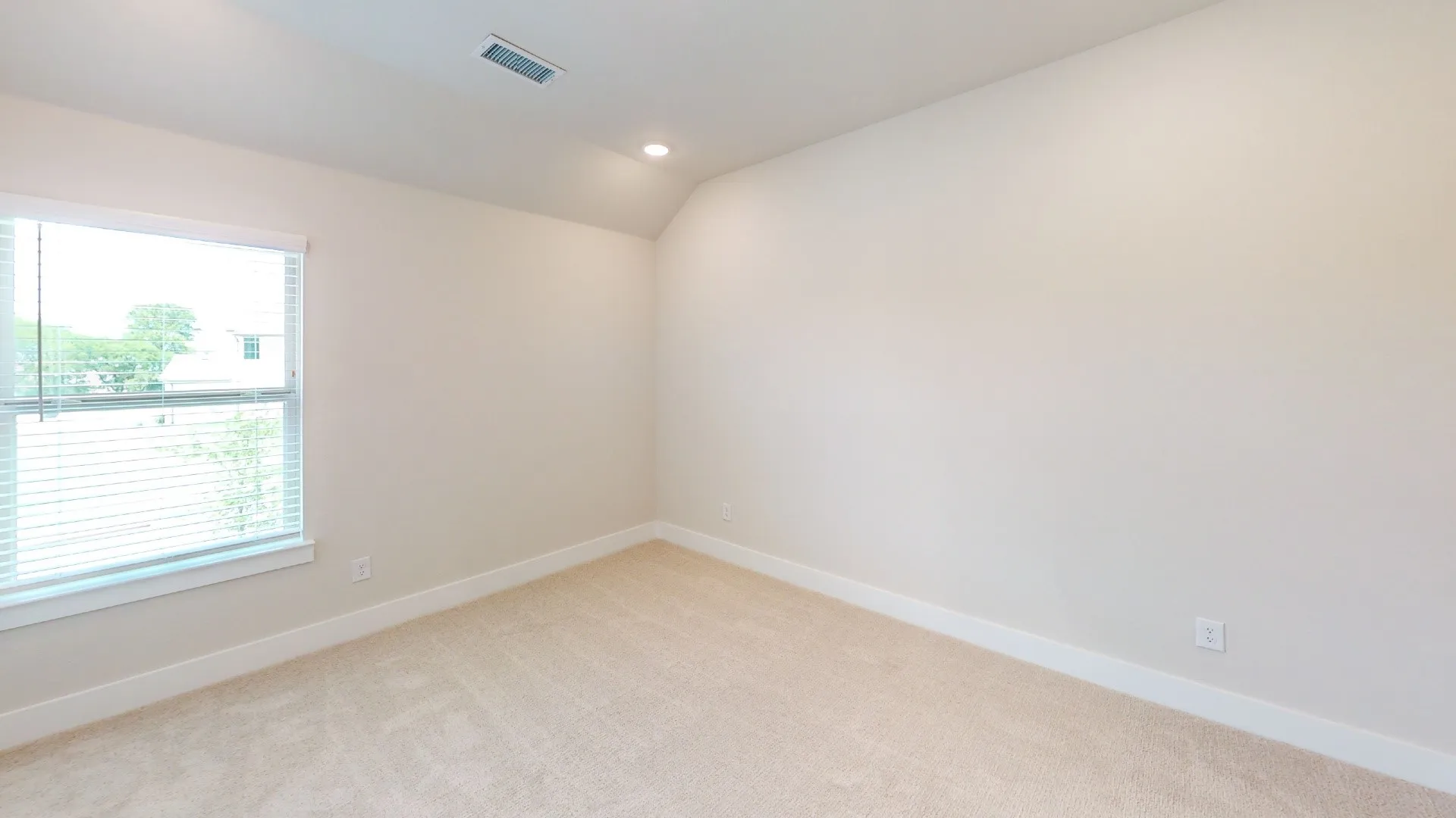 Carpeted room featuring a single window with blinds, recessed lighting, and a sloped ceiling