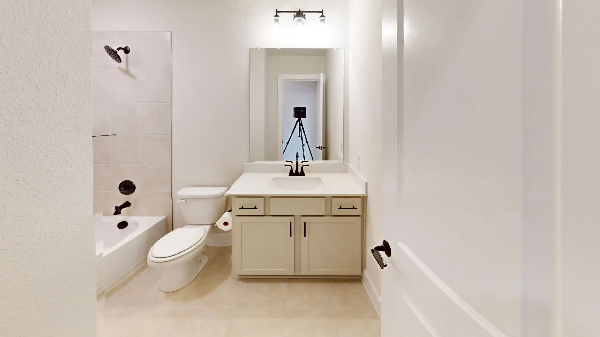 Full bathroom featuring a single vanity with a white countertop and base cabinetry, a toilet, and a bathtub with an integrated shower