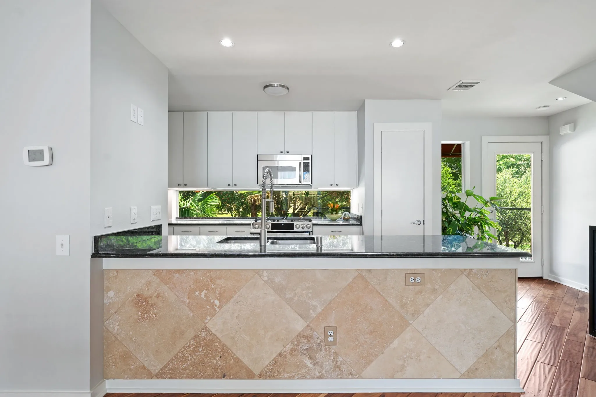Kitchen island with a dark countertop and diagonal tile-finish facing