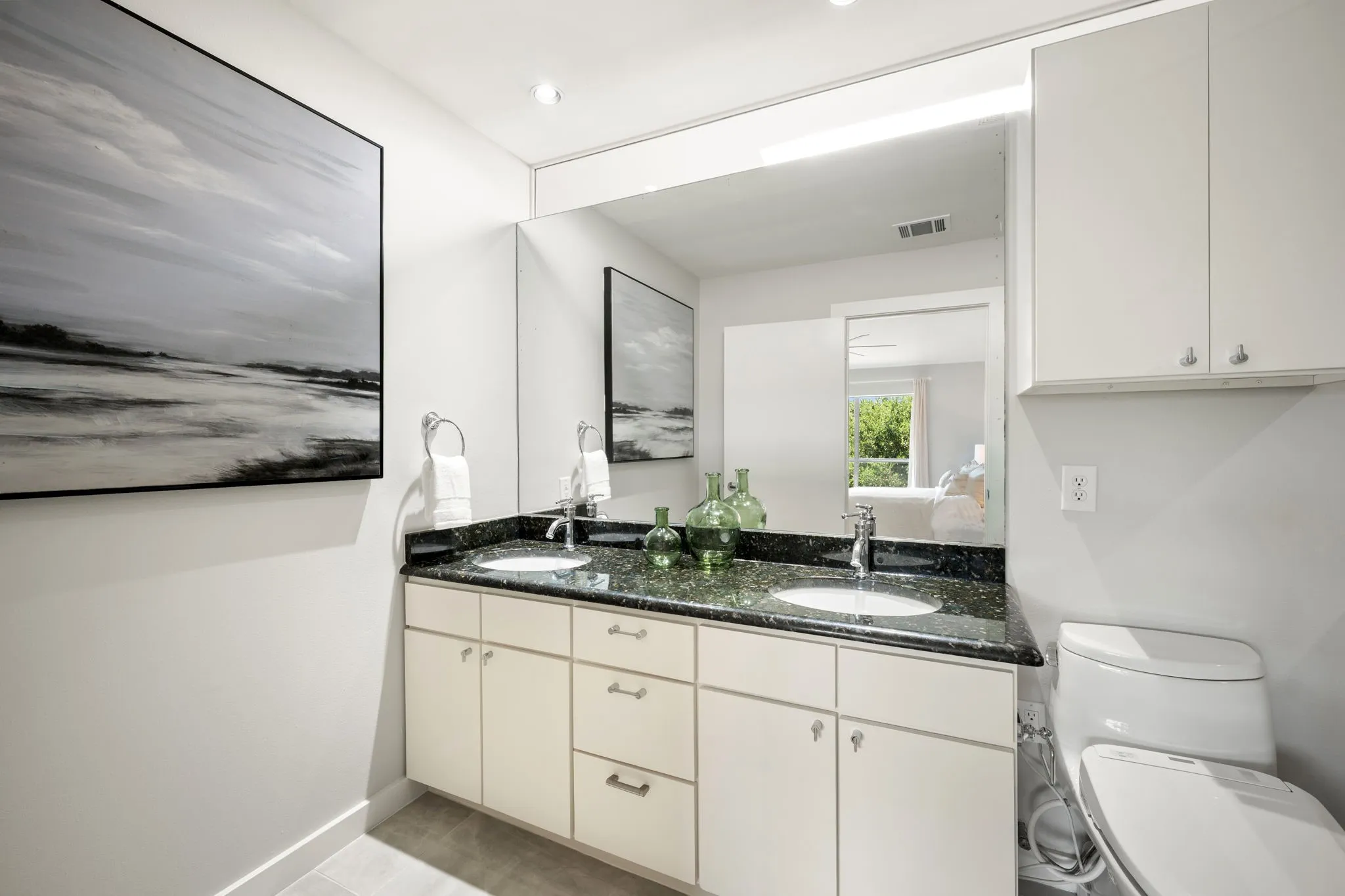 Dual basin vanity with a speckled countertop, integrated sinks, and polished chrome fixtures