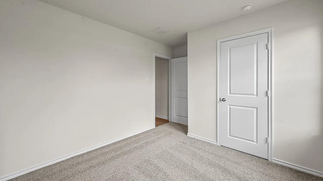 Carpeted room with light-toned walls and white trim