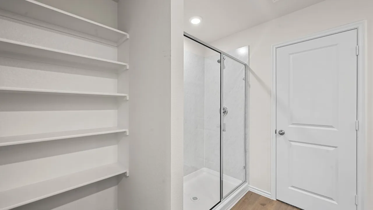 Walk-in shower featuring a clear glass enclosure and tiled walls