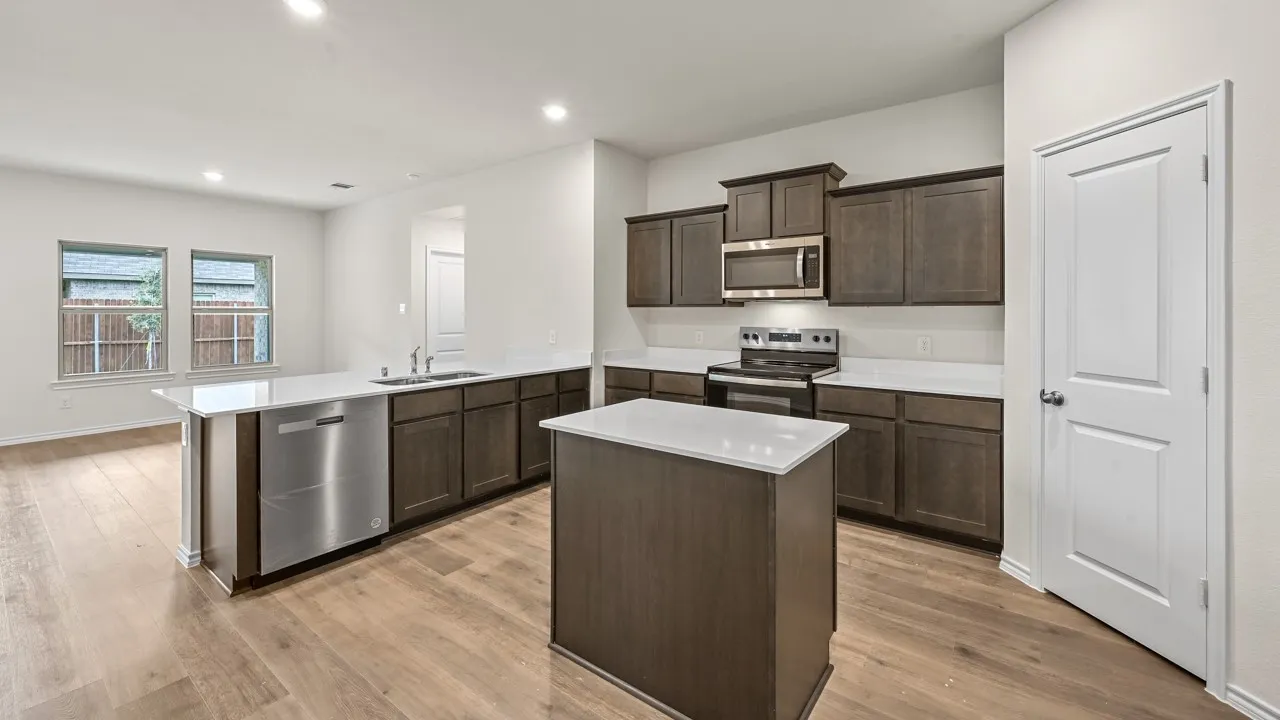 Contemporary kitchen featuring a central island, wood-finish flooring, recessed lighting, and stainless steel appliances