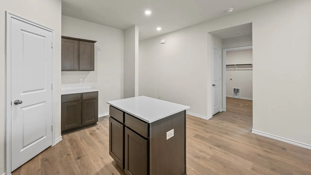Kitchen island featuring dark wood-finish cabinetry and a light-toned countertop