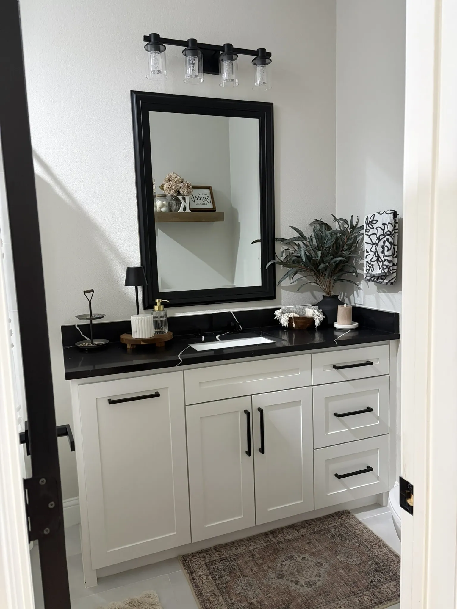 White shaker vanity with black countertop and integrated sink