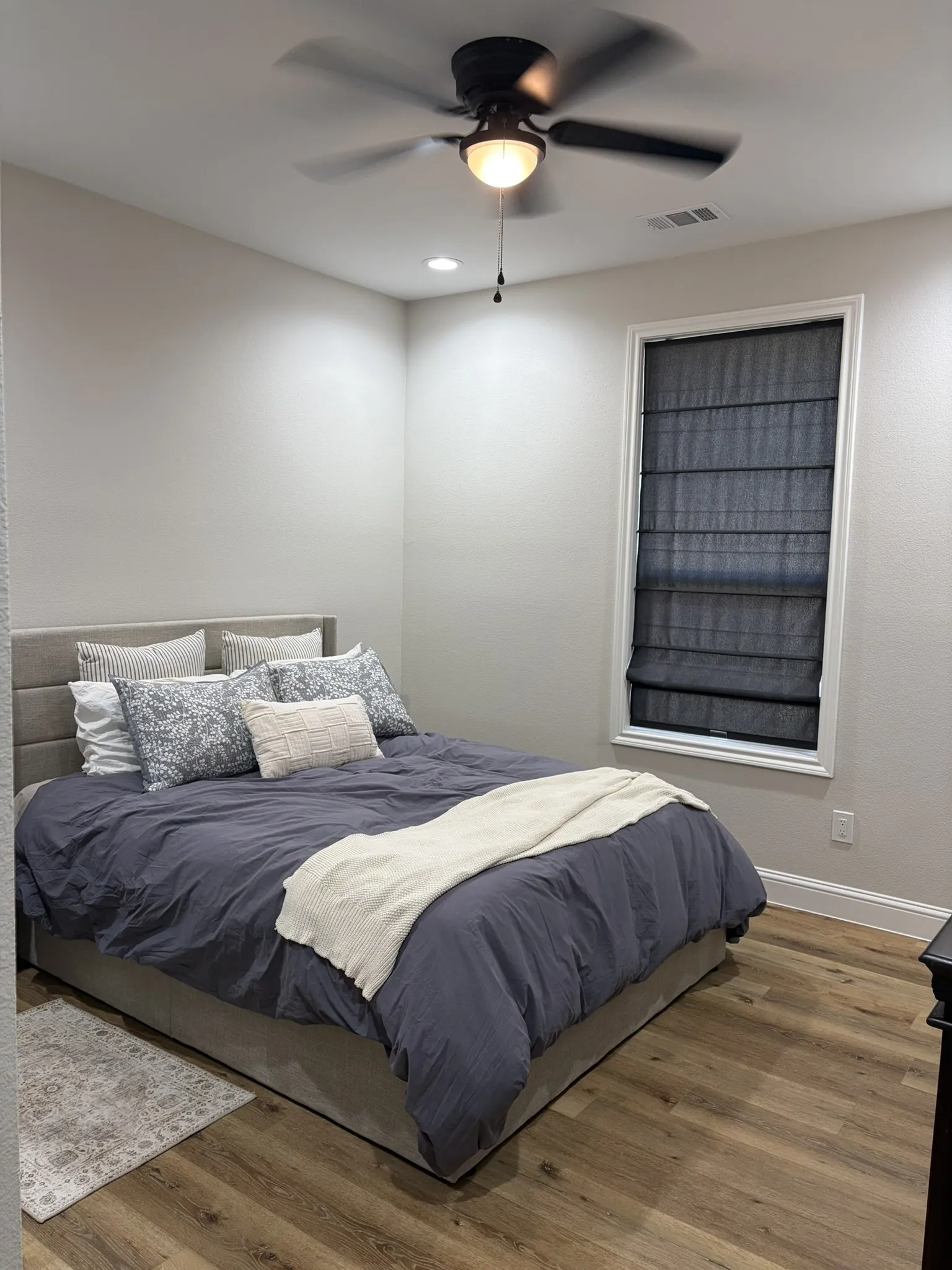 Room featuring wood-finish flooring, a window with roman shades, recessed lighting, and a ceiling fan with integrated light
