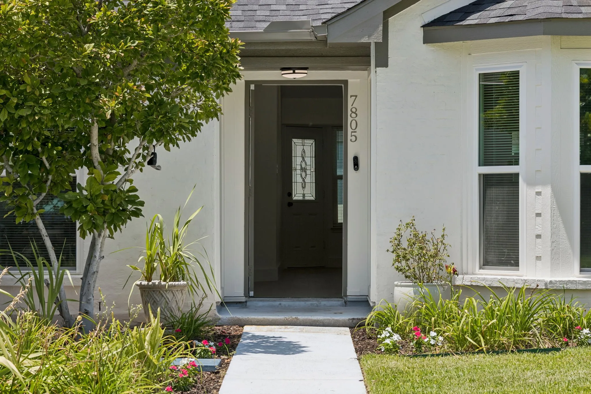 A covered front porch invites guests inside, offering protection from the elements and a charming entrance to the home.
