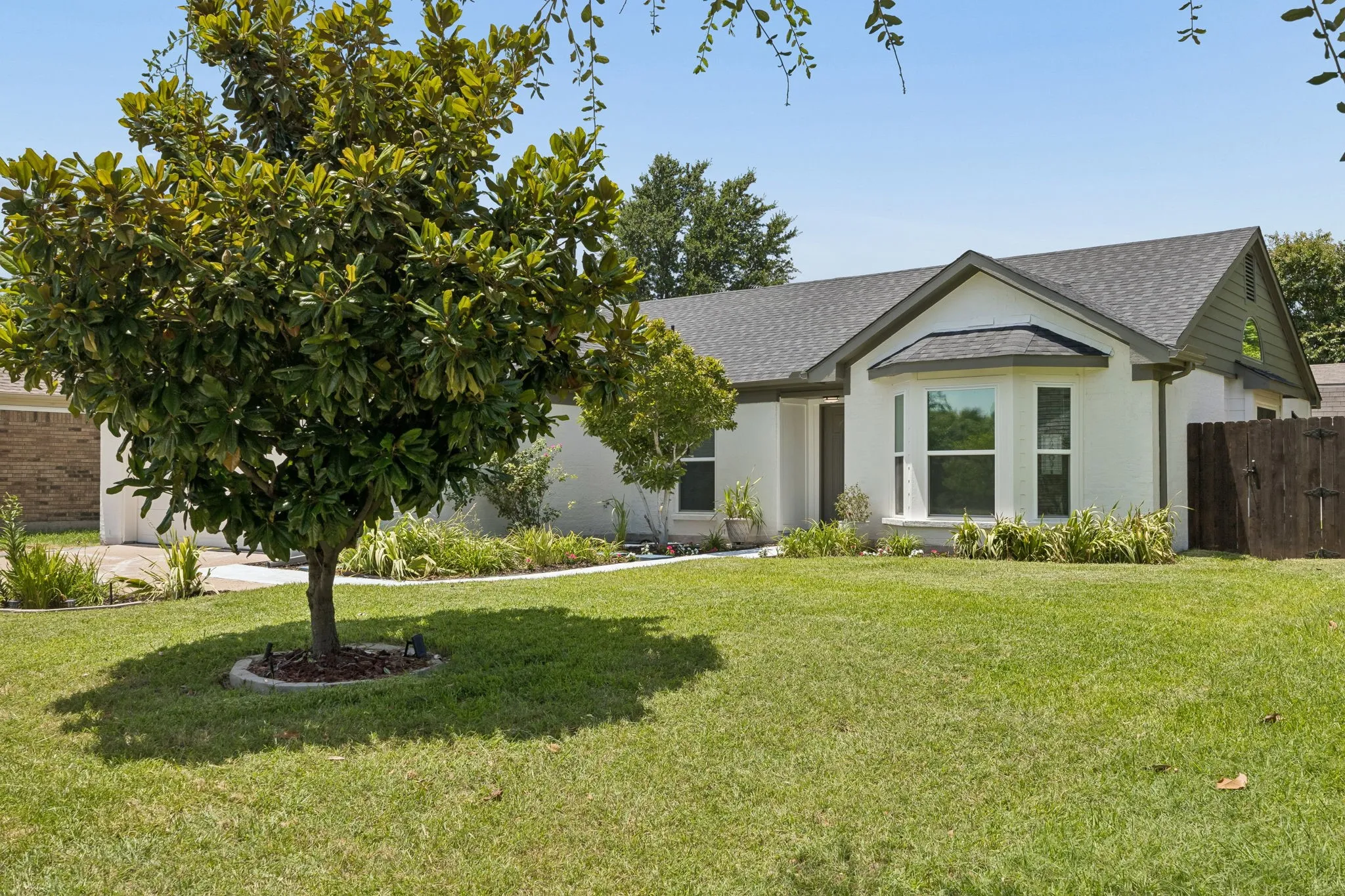 A sweeping front lawn, mature shade trees, and thoughtfully designed landscaping provide a peaceful setting and warm first impression.