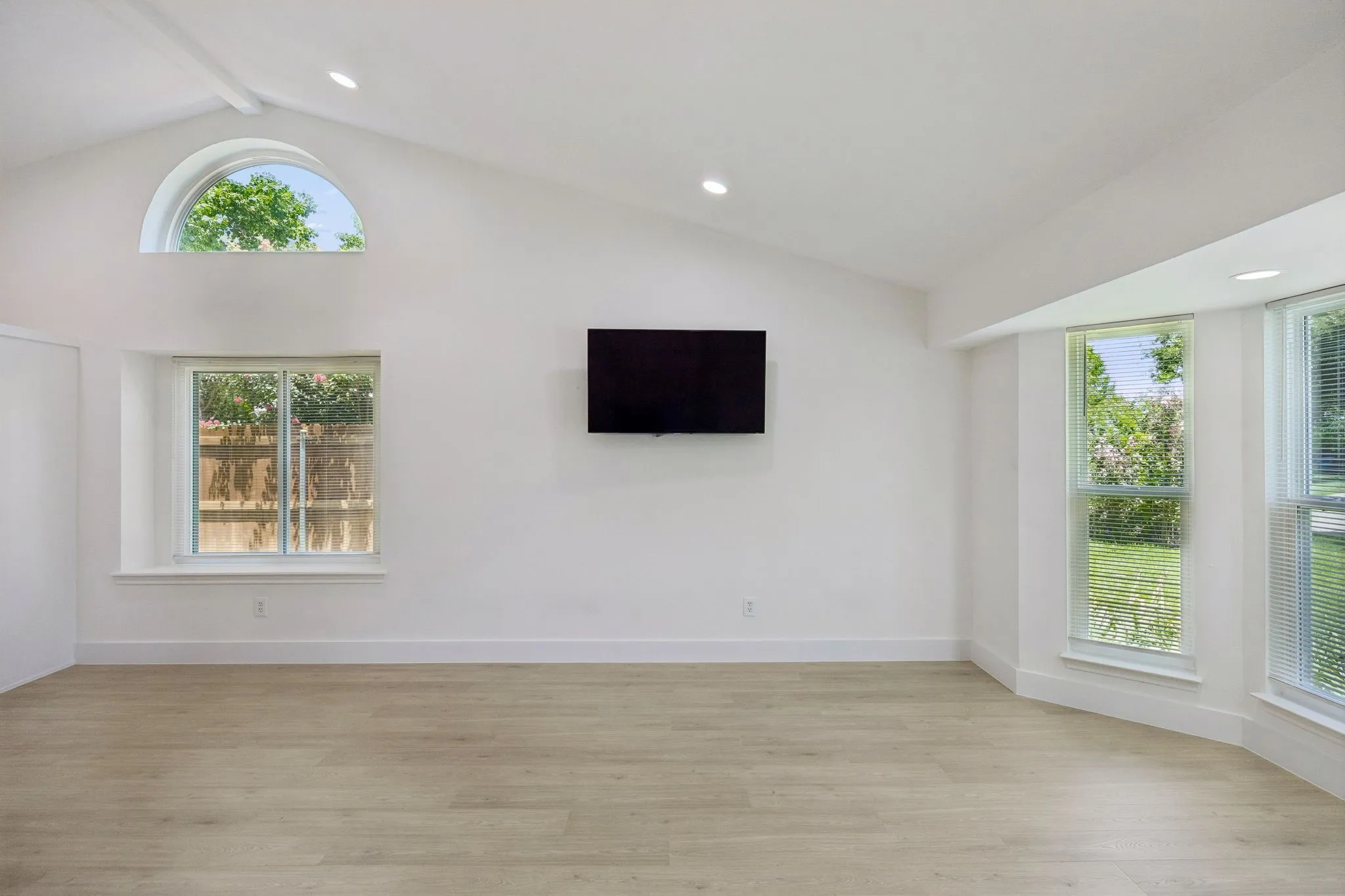 Large front-facing windows (pictured on the right) bathe the living room in natural light while highlighting the home's airy, open design.