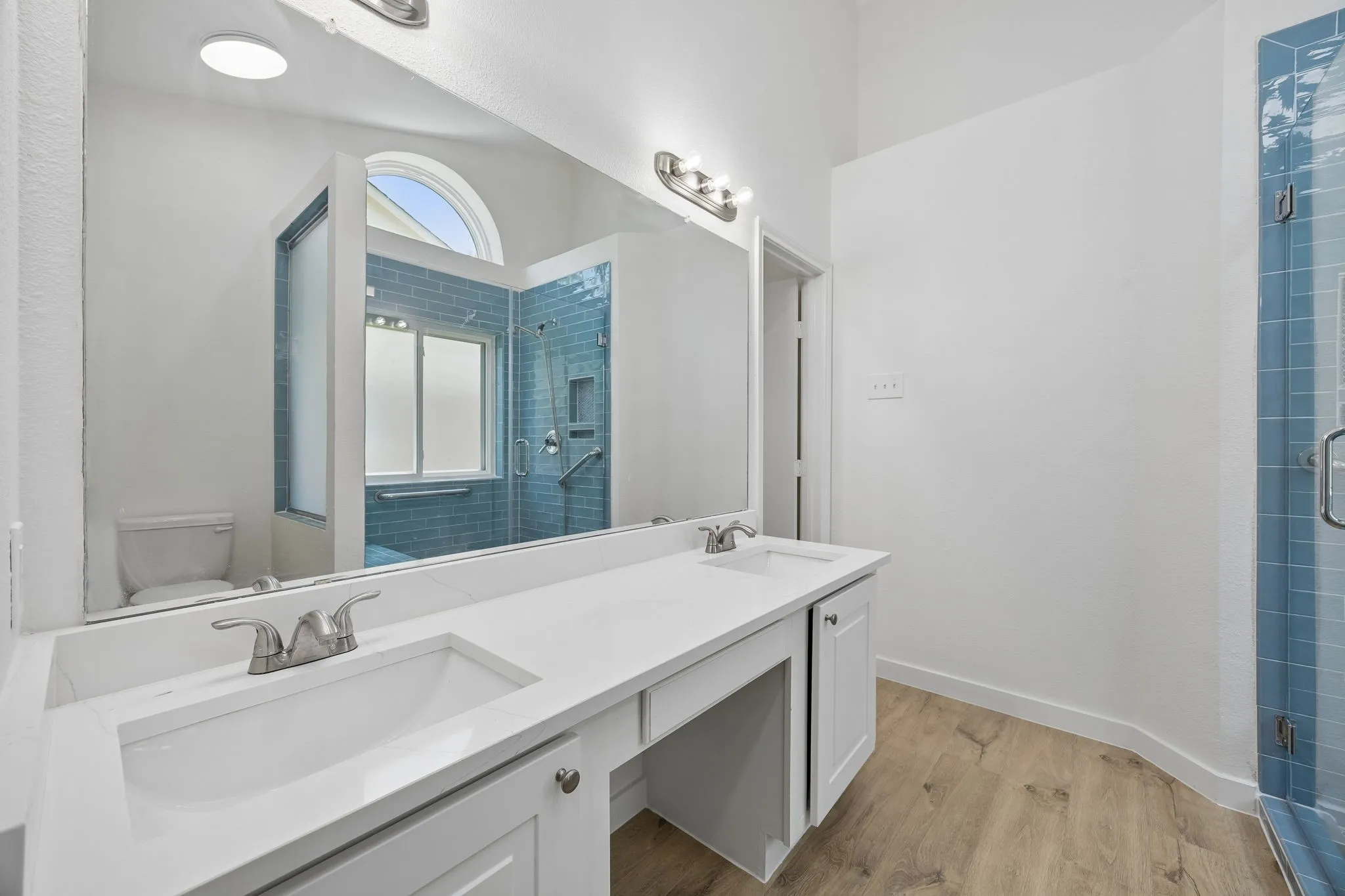 The spacious double vanity provides generous counter space, modern fixtures, and abundant storage, making busy mornings effortless while maintaining a clean, sophisticated design.