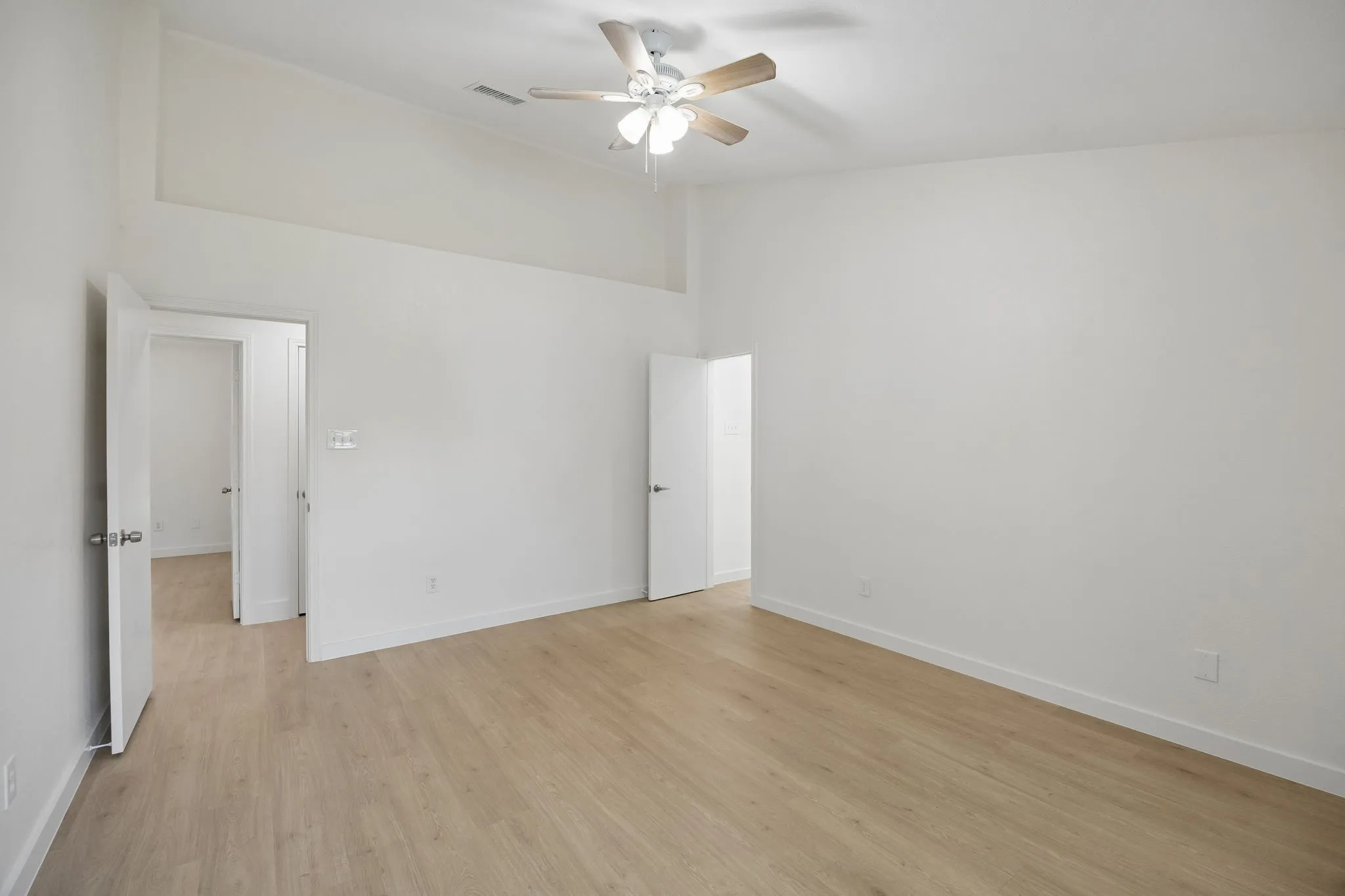 Designed with comfort in mind, the generous primary bedroom offers ample space for a sitting area while maintaining a bright, airy atmosphere.