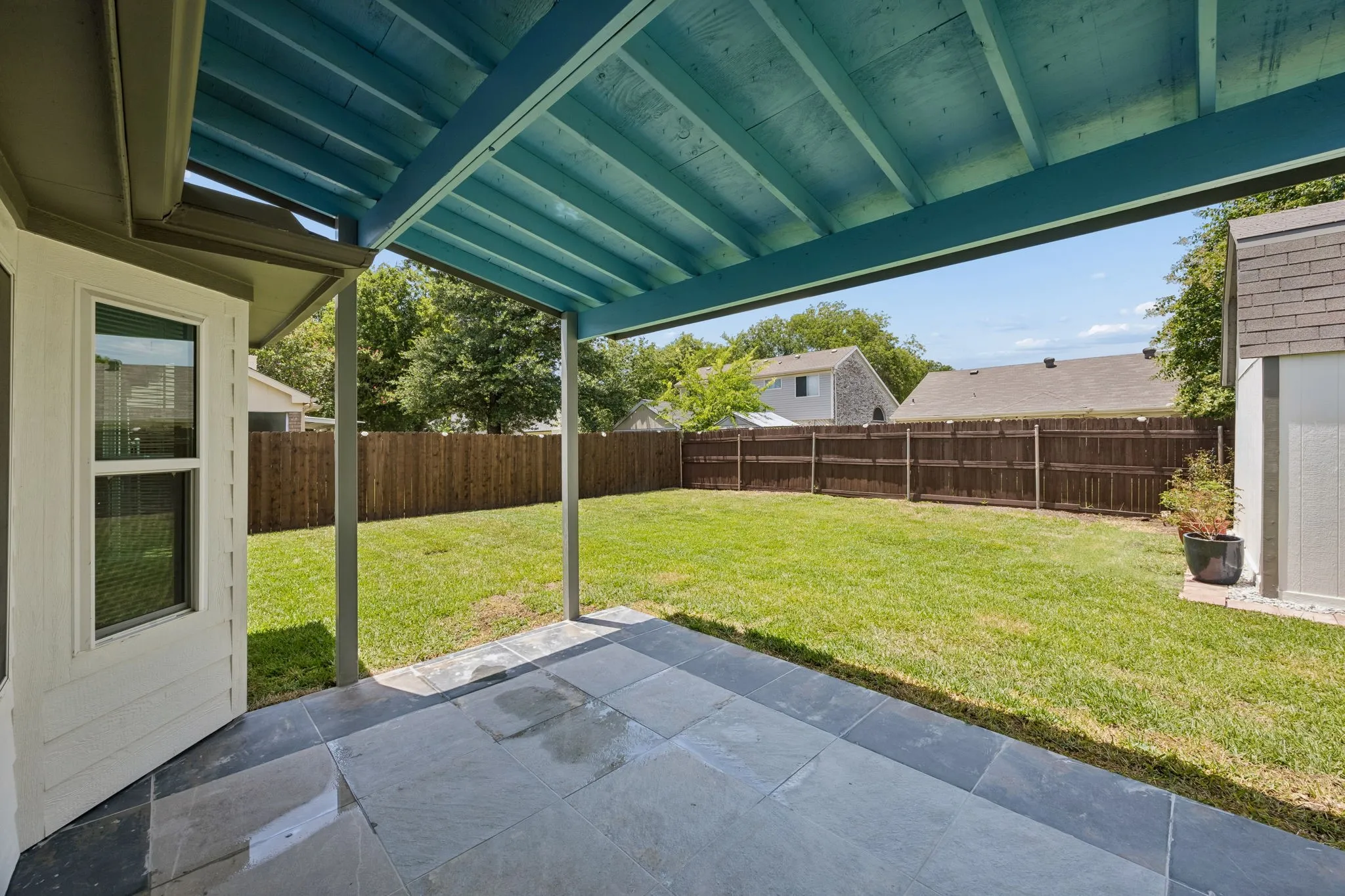 Covered patio offers the perfect place to relax, grill, or entertain while overlooking the spacious backyard.