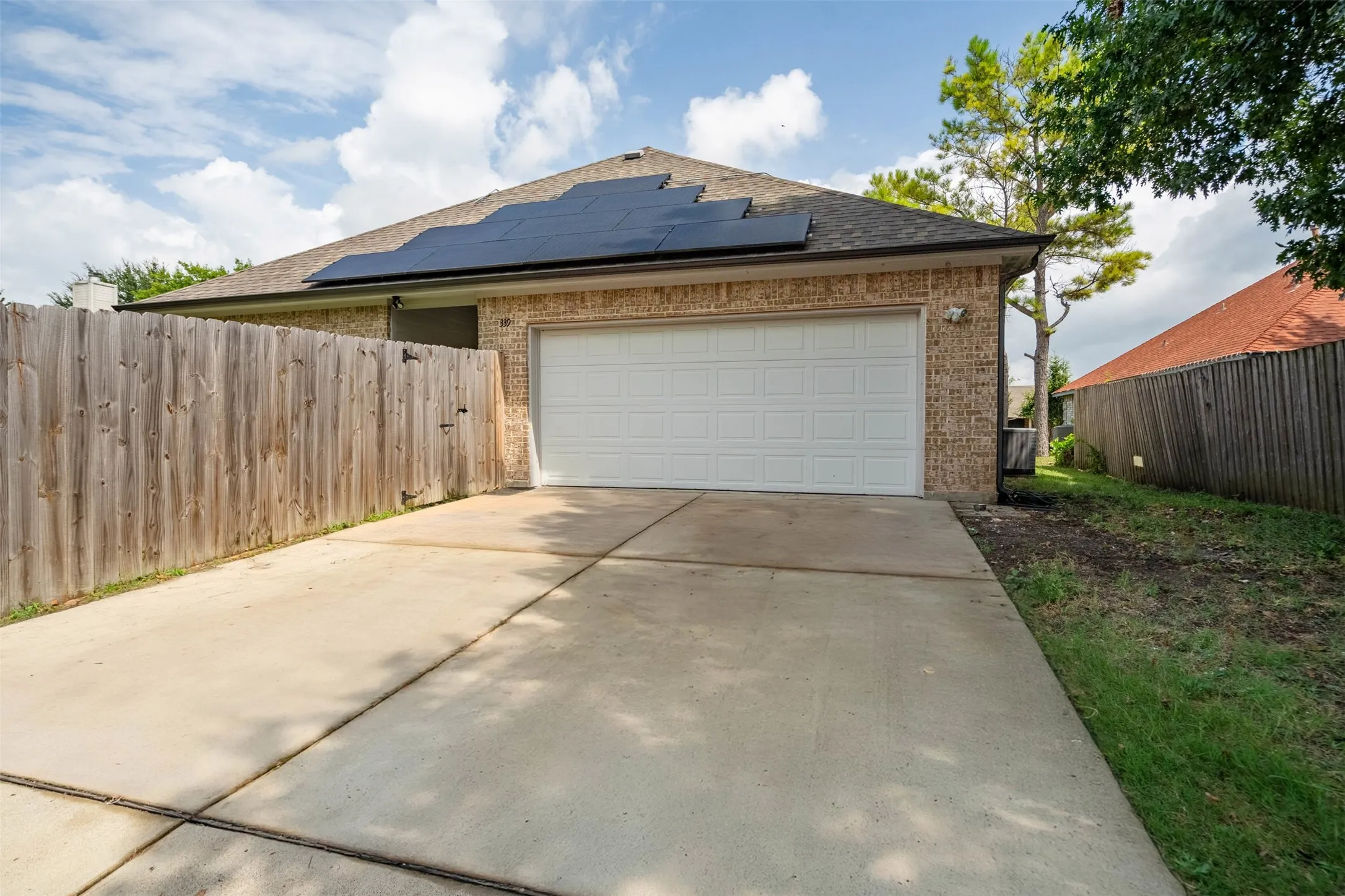 Garage with solar panels and concrete driveway