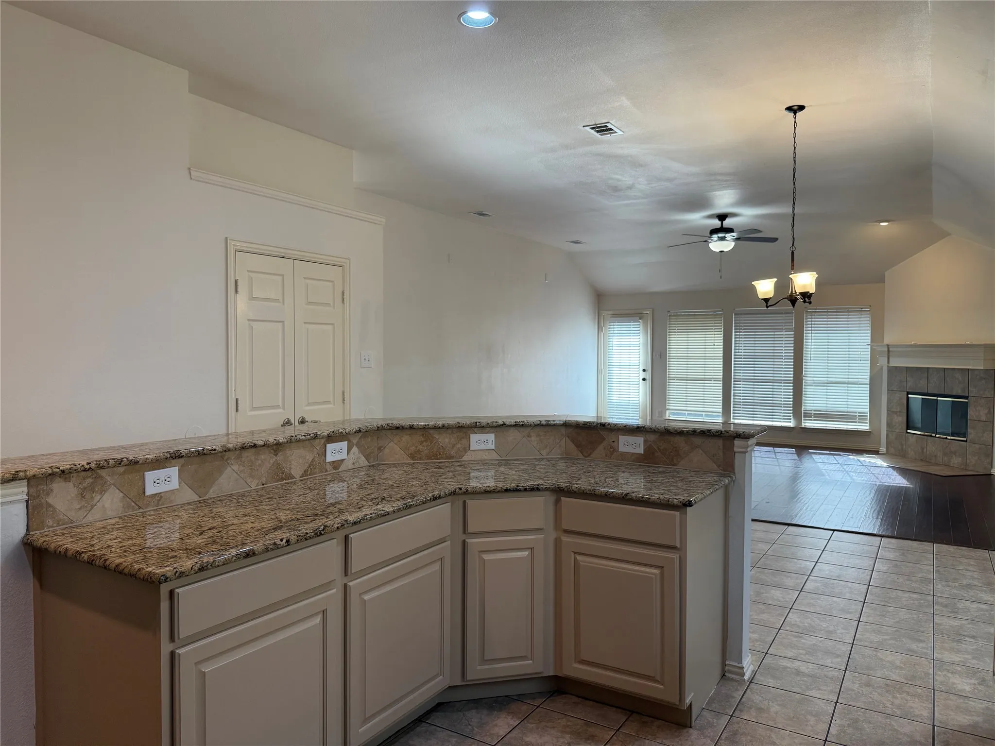 Kitchen peninsula with granite countertops and a tiled backsplash