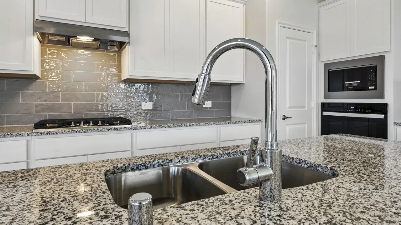 Kitchen island featuring a double basin stainless steel sink with a high-arch chrome faucet