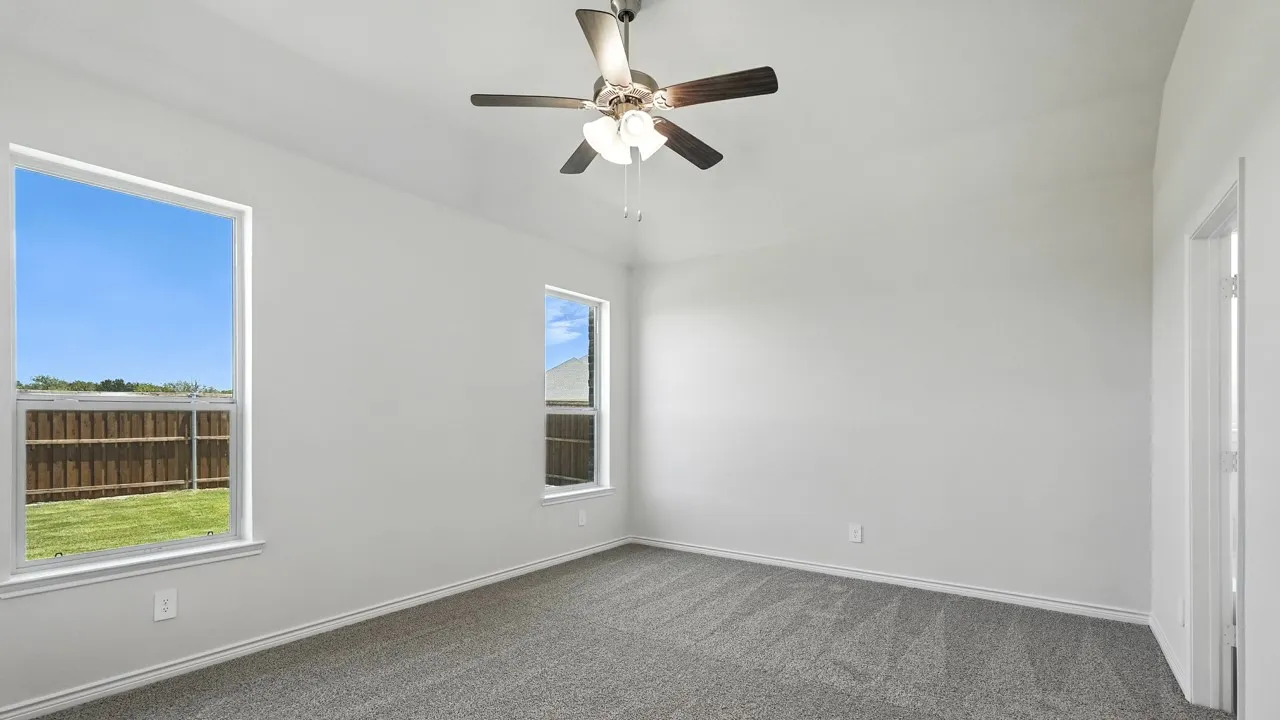 Carpeted interior space featuring white walls and a vaulted ceiling