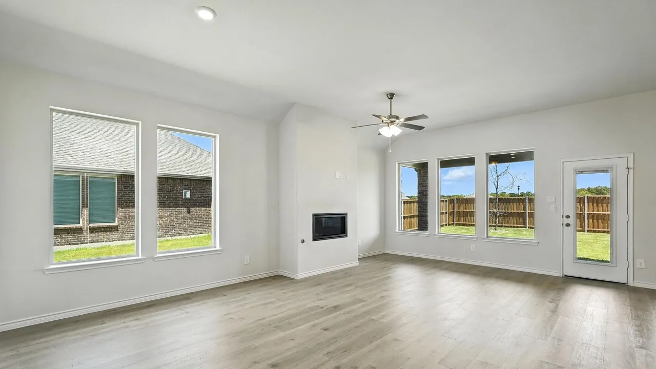 Spacious interior featuring wood-finish flooring, recessed lighting, and a modern fireplace