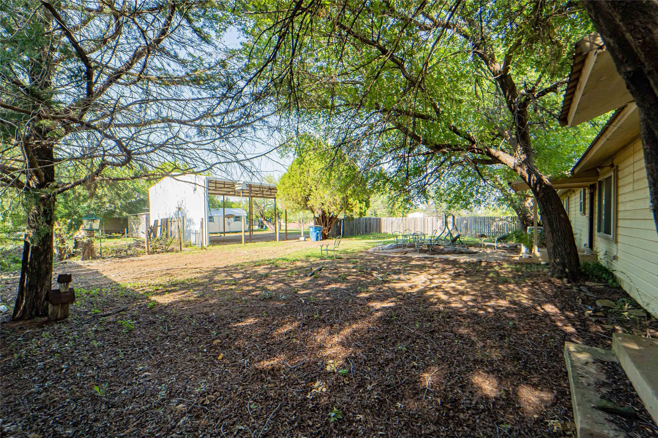 Expansive backyard with a mix of established trees and open ground