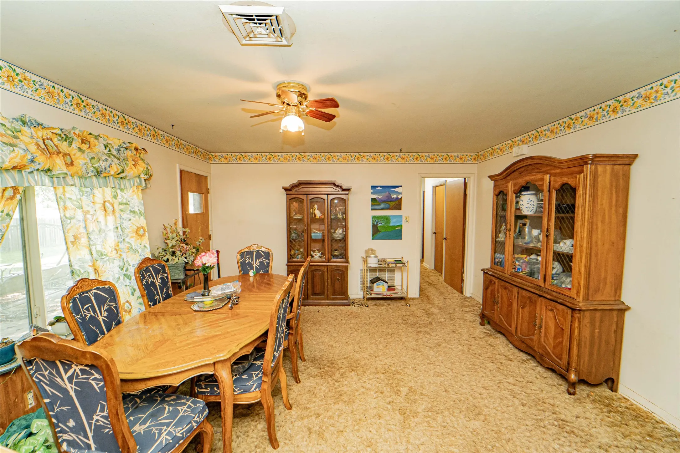 Carpeted interior with a ceiling fan light fixture