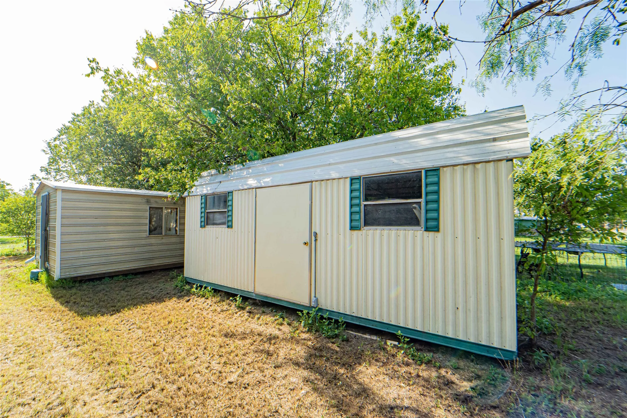Two utility sheds featuring corrugated siding and metal roofs