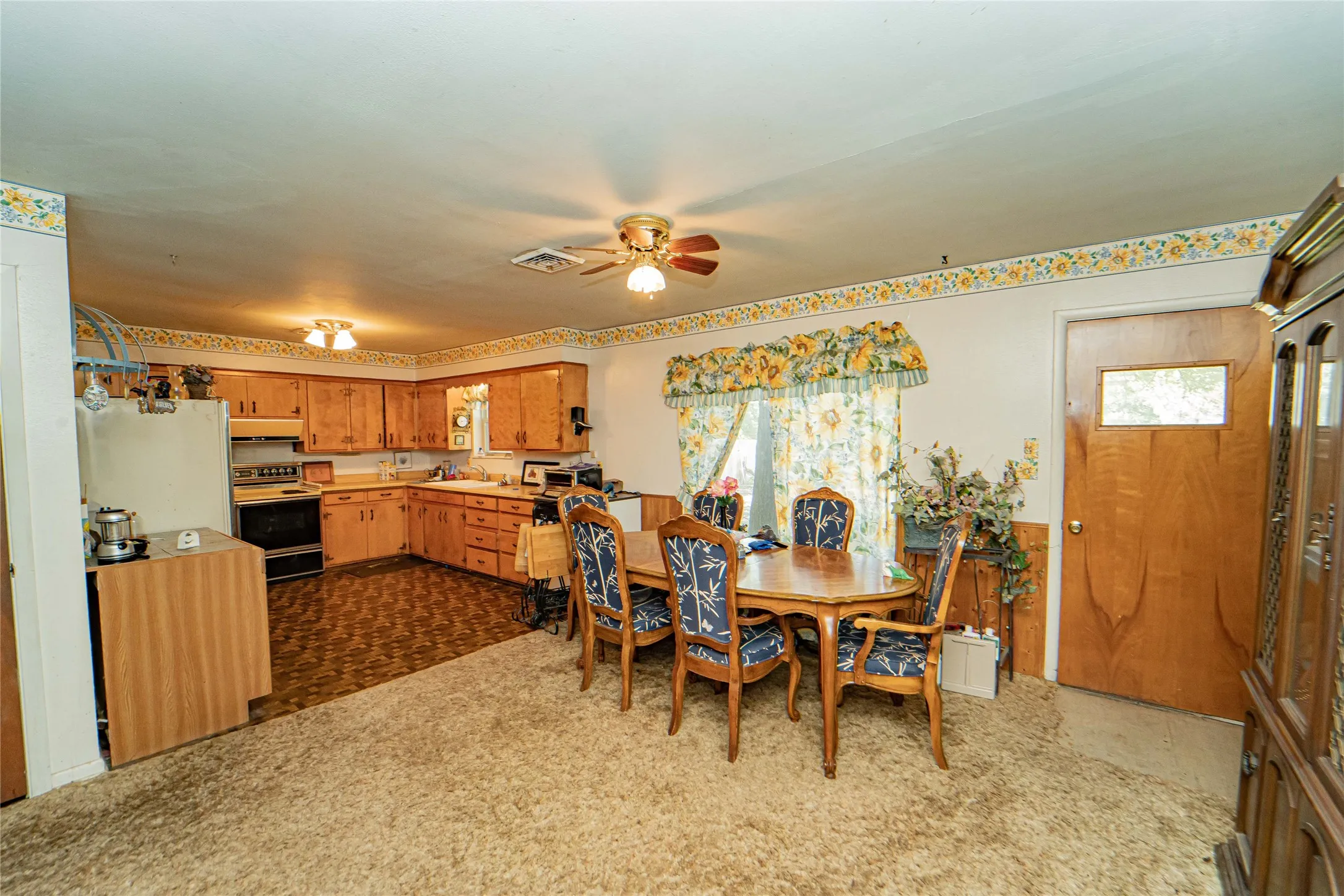 Kitchen and dining area featuring wood cabinetry, laminate countertops, and brown flooring