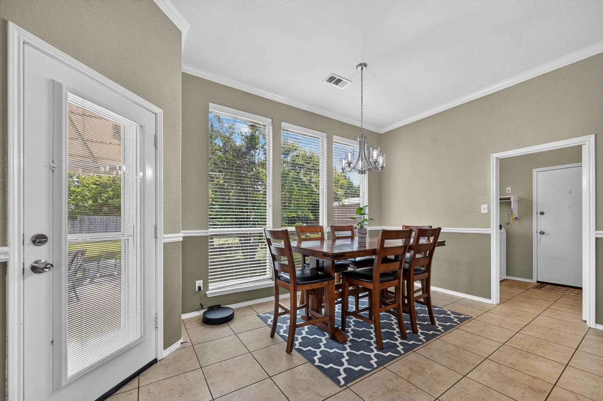 Dining area featuring floor-to-ceiling windows, tile flooring, a chandelier, and a glass-paneled exterior door
