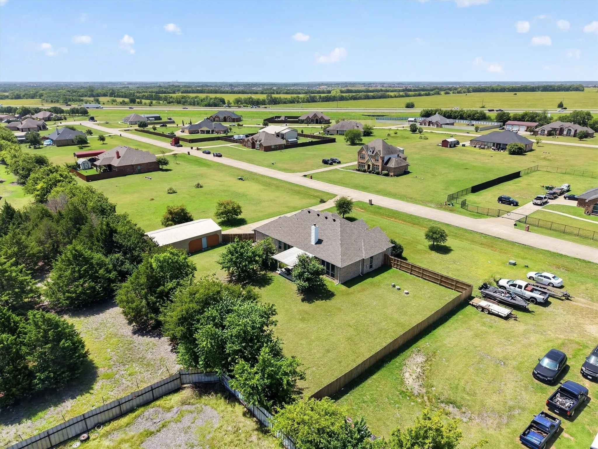 Expansive property featuring a single-story residence with a gabled roof and brick exterior