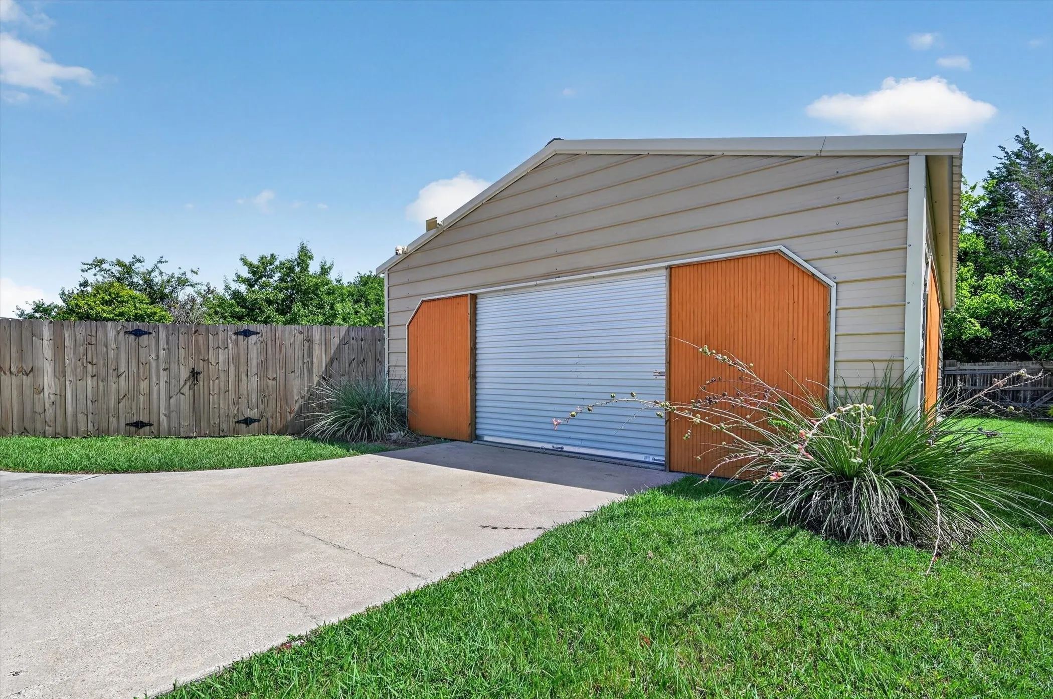 Detached garage with a roll-up door, horizontal siding, and a gabled roofline