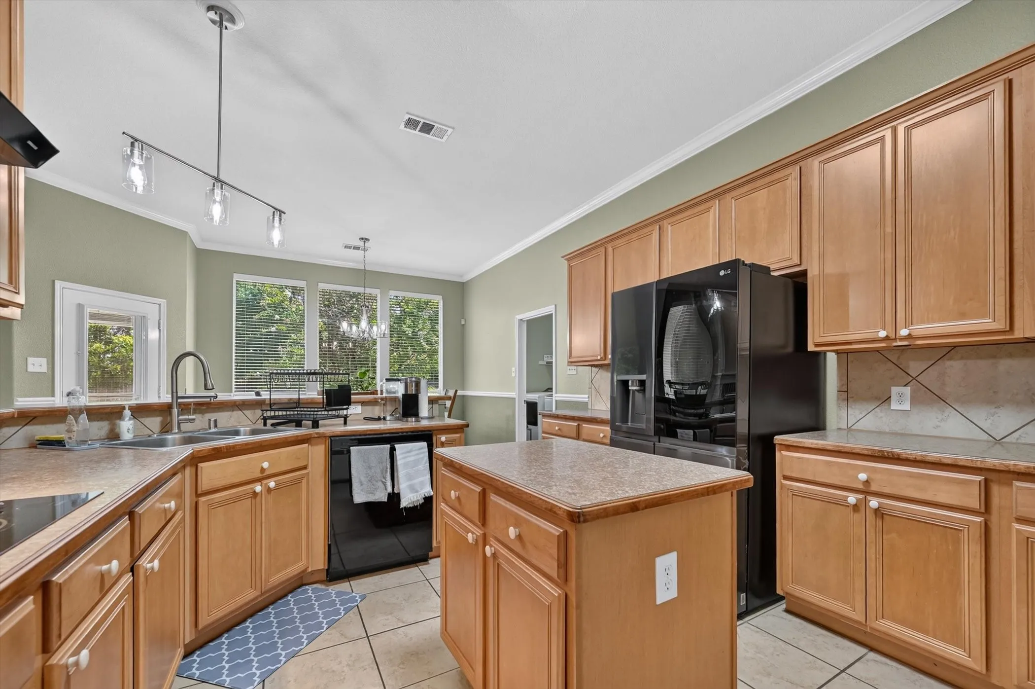 Kitchen featuring recessed panel cabinetry, a central island, and tile flooring