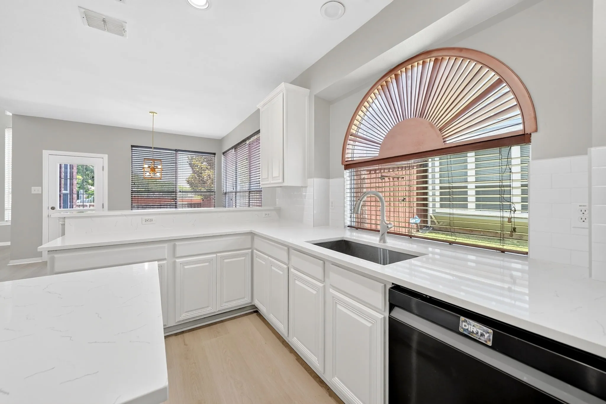 White cabinetry, quartz countertops and updated backsplash