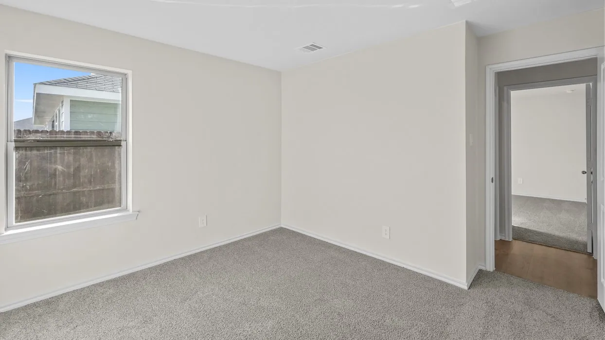 Room featuring light gray wall paint, gray carpet flooring, white baseboards, and a window with white trim